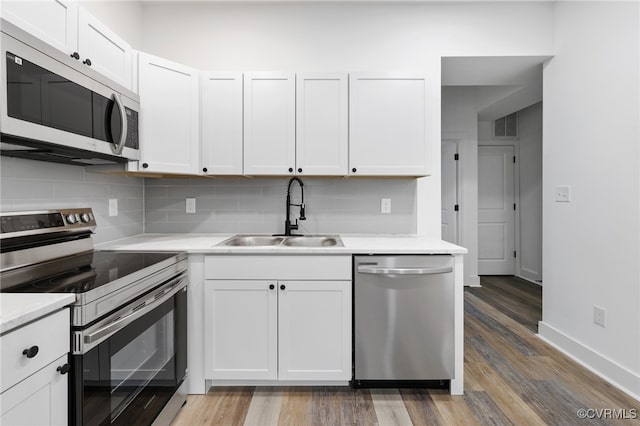 kitchen featuring dark hardwood / wood-style flooring, white cabinetry, sink, and appliances with stainless steel finishes