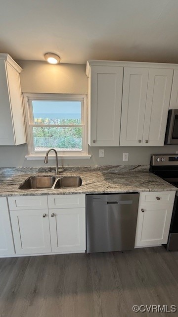 kitchen featuring white cabinets, sink, dark hardwood / wood-style floors, appliances with stainless steel finishes, and light stone counters