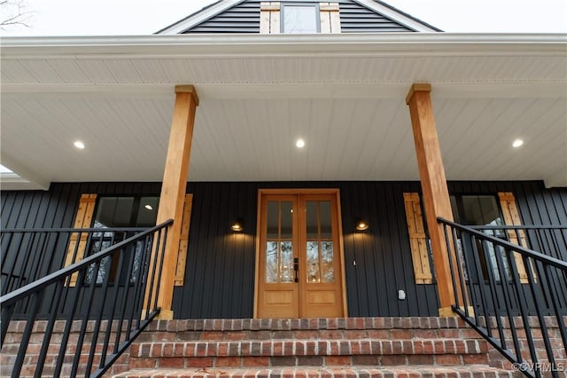 view of exterior entry featuring covered porch and french doors