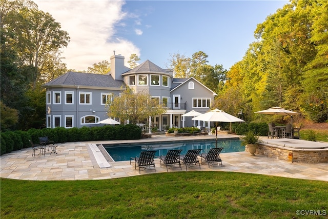 back of house with a patio and a lawn