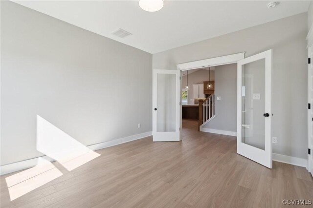 empty room with french doors and light hardwood / wood-style floors