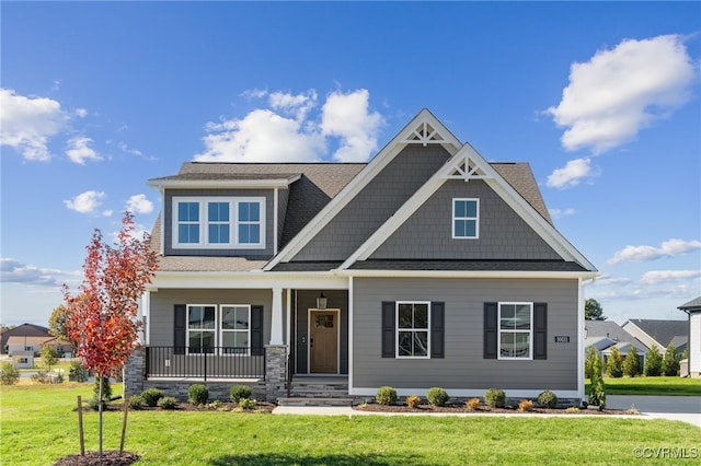 craftsman inspired home featuring a porch and a front lawn