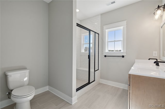 bathroom featuring toilet, an enclosed shower, and vanity