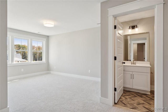 interior space featuring dark parquet floors, sink, and ensuite bath