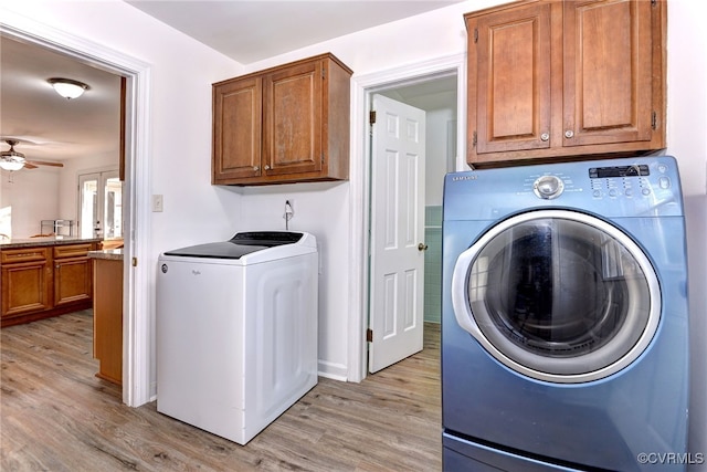 laundry room featuring cabinets, ceiling fan, separate washer and dryer, and light hardwood / wood-style floors