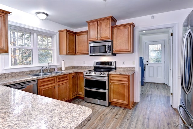 kitchen featuring sink, light hardwood / wood-style floors, and appliances with stainless steel finishes