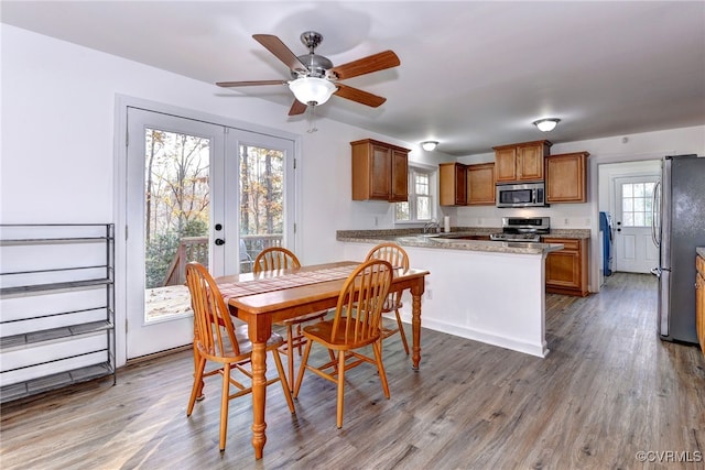 dining area featuring sink, wood-type flooring, french doors, and ceiling fan