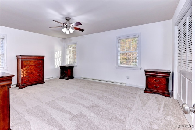 carpeted bedroom featuring ceiling fan, a baseboard radiator, multiple windows, and a closet