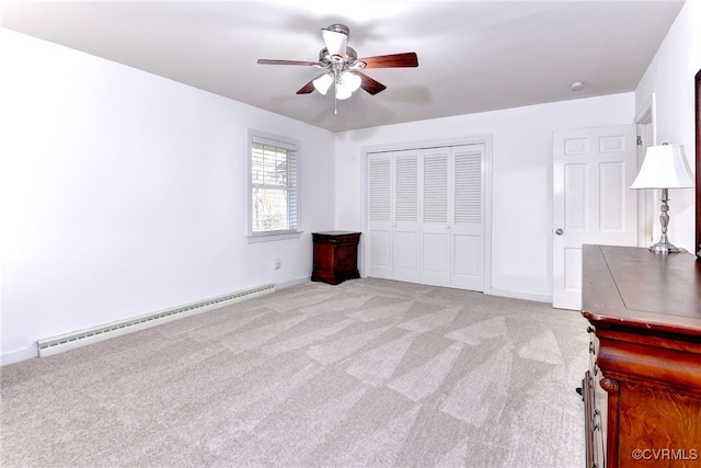 unfurnished bedroom featuring baseboard heating, ceiling fan, light carpet, and a closet