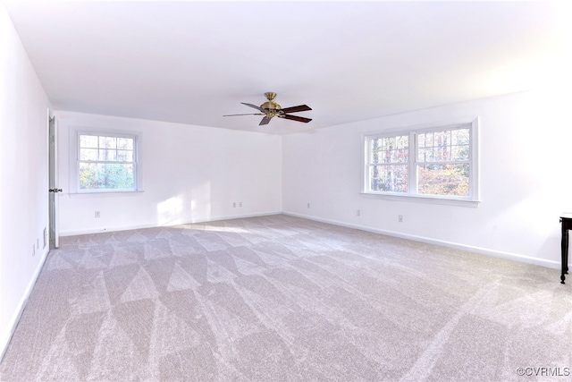 carpeted spare room featuring ceiling fan