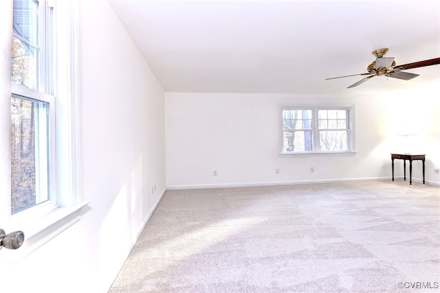 carpeted empty room featuring ceiling fan and a wealth of natural light