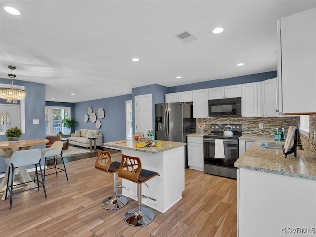 kitchen featuring white cabinetry, sink, a kitchen island, and appliances with stainless steel finishes