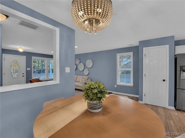 dining area featuring an inviting chandelier and light wood-type flooring