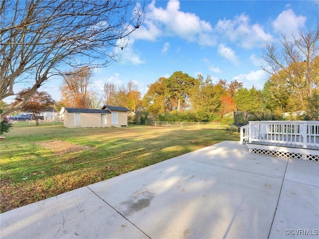 view of yard featuring an outbuilding, a deck, and a patio