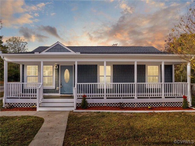 view of front of home with a lawn and a porch