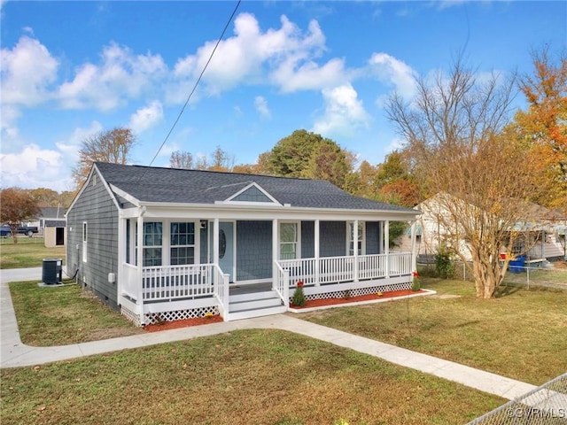 view of front of property with cooling unit, covered porch, and a front yard