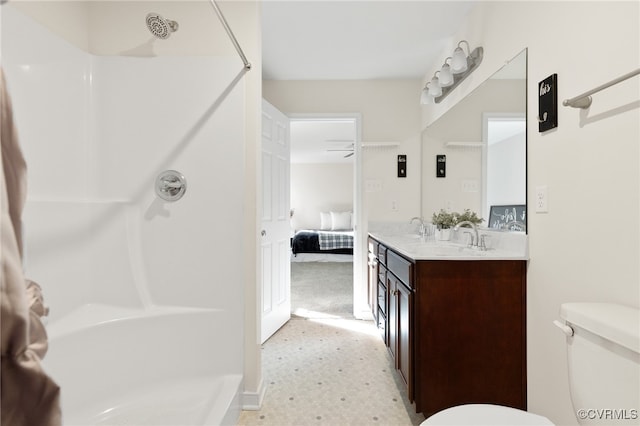 bathroom featuring vanity, toilet, walk in shower, and ceiling fan