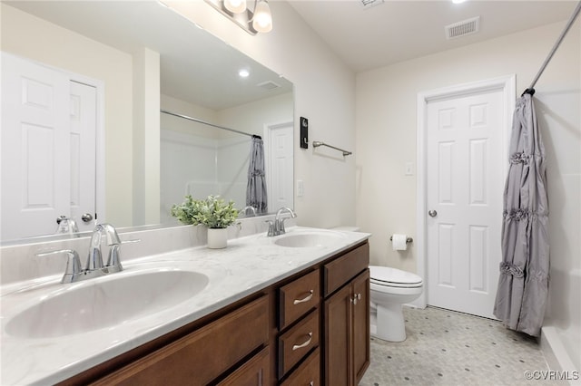 bathroom featuring vanity, toilet, and curtained shower