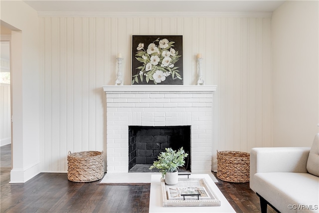 living room featuring dark hardwood / wood-style flooring and a brick fireplace