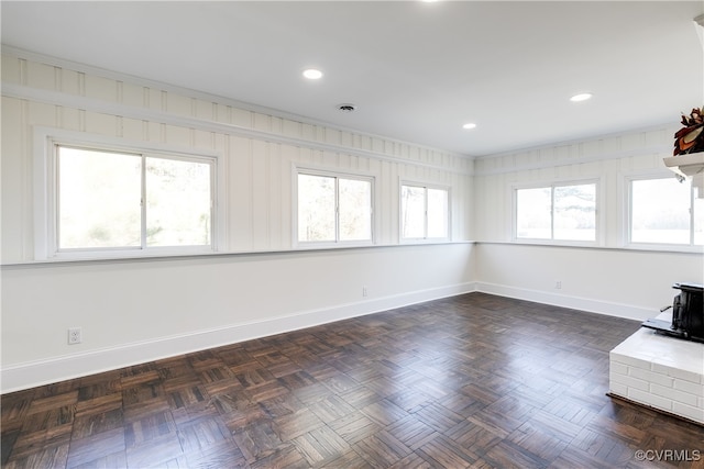 spare room featuring dark parquet floors and plenty of natural light