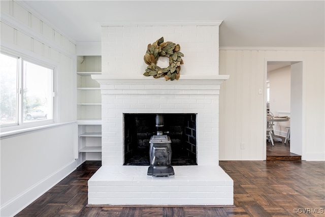 details with built in features, parquet flooring, ornamental molding, and a brick fireplace