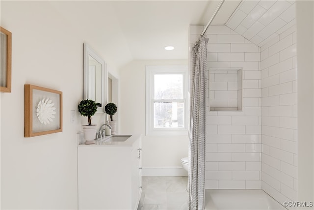 bathroom with vanity, toilet, walk in shower, and lofted ceiling