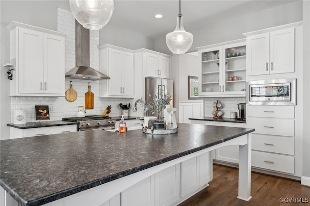 kitchen with white cabinetry, wall chimney exhaust hood, pendant lighting, and premium appliances