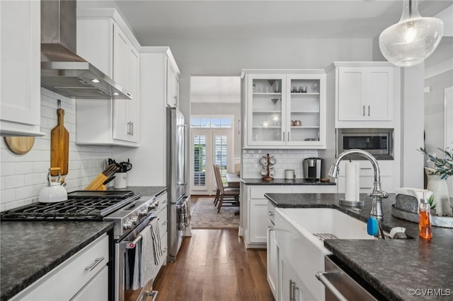 kitchen with white cabinetry, wall chimney exhaust hood, stainless steel appliances, tasteful backsplash, and pendant lighting