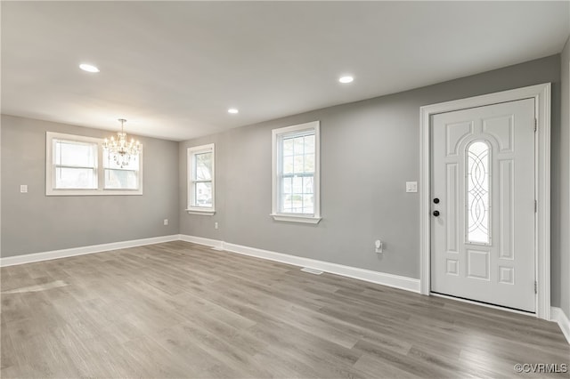 entrance foyer featuring light hardwood / wood-style flooring and an inviting chandelier