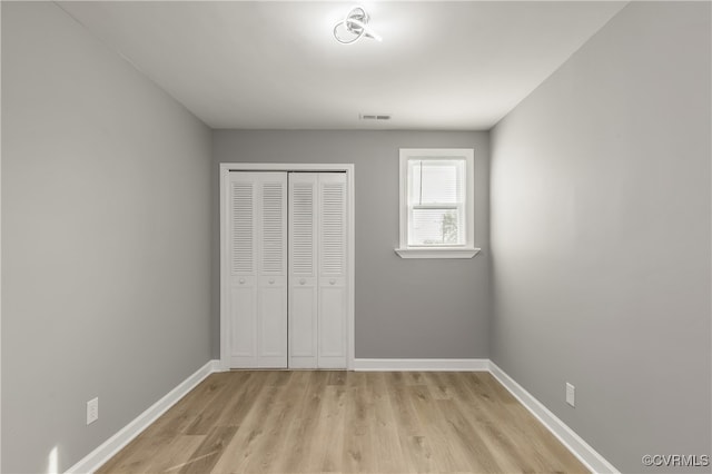 unfurnished bedroom featuring a closet and light hardwood / wood-style flooring