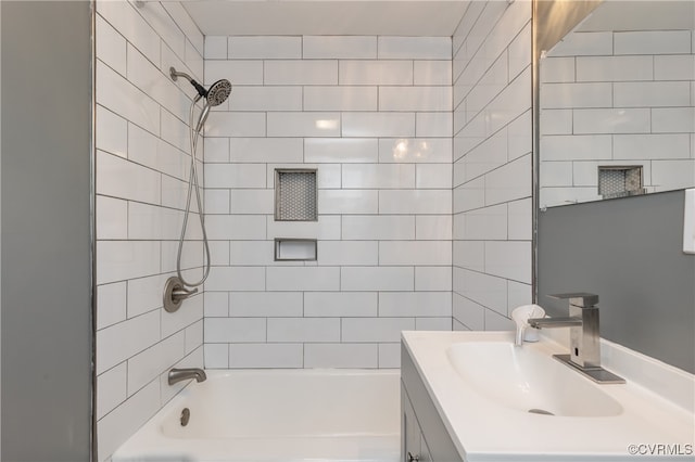 bathroom with tiled shower / bath combo and vanity