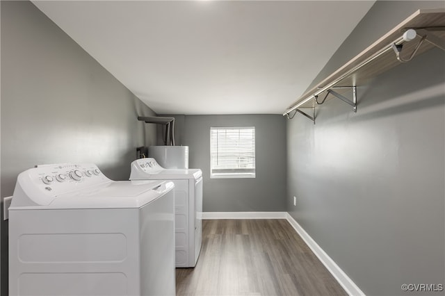 laundry room with separate washer and dryer, dark wood-type flooring, and water heater