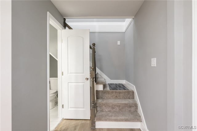 stairway with hardwood / wood-style floors and a barn door