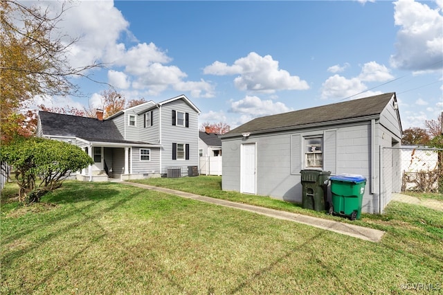 rear view of house featuring a yard and central air condition unit