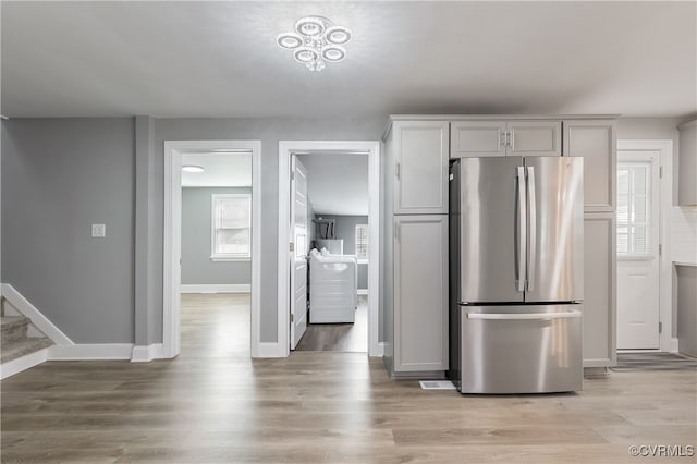 kitchen with stainless steel fridge and light hardwood / wood-style flooring