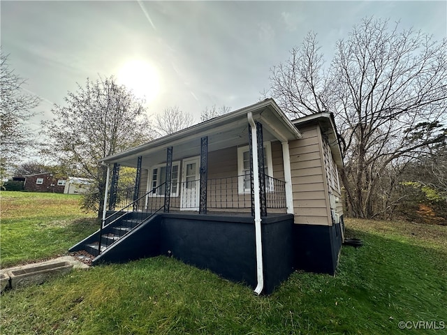 view of home's exterior featuring a porch and a yard