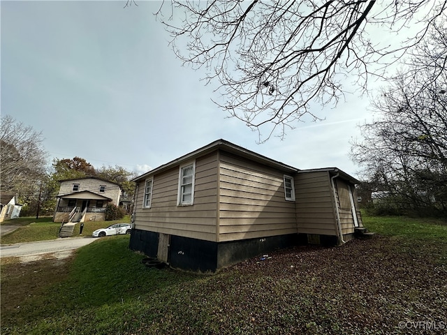 view of side of home with a yard