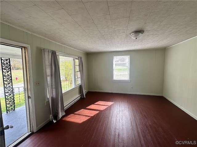 empty room with dark hardwood / wood-style floors and ornamental molding