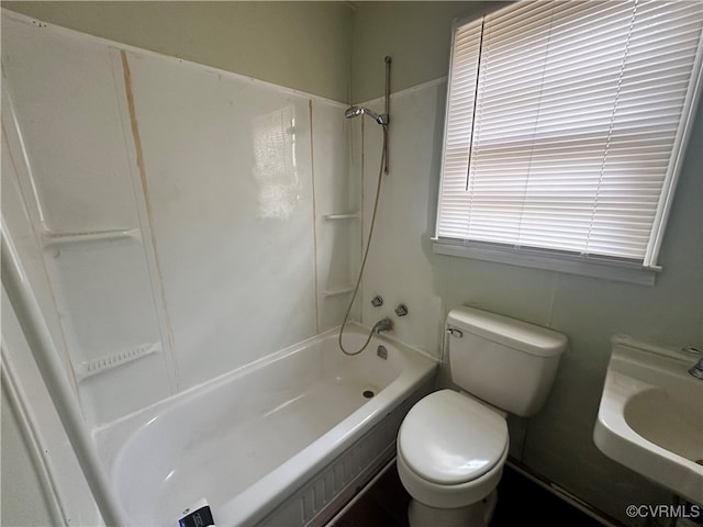 full bathroom featuring sink, tub / shower combination, and toilet