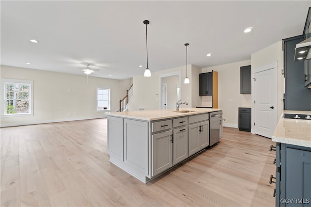 kitchen with gray cabinets, a wealth of natural light, ceiling fan, and stainless steel dishwasher