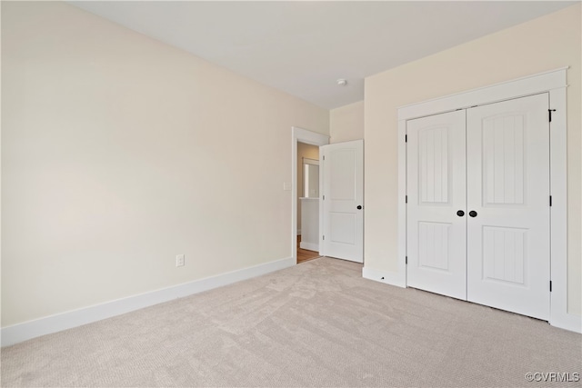 unfurnished bedroom featuring light carpet and a closet