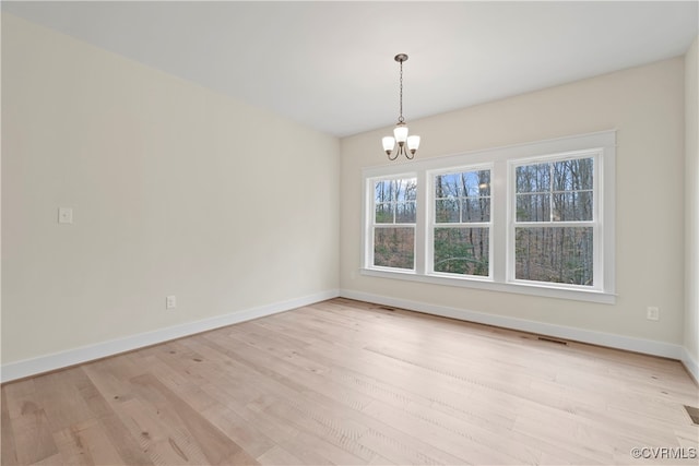 unfurnished dining area with light hardwood / wood-style floors and a notable chandelier