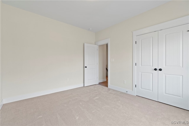 unfurnished bedroom with light carpet and a closet