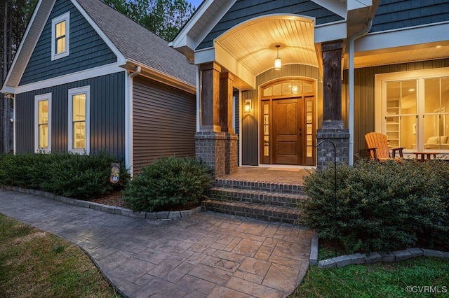 view of exterior entry featuring covered porch