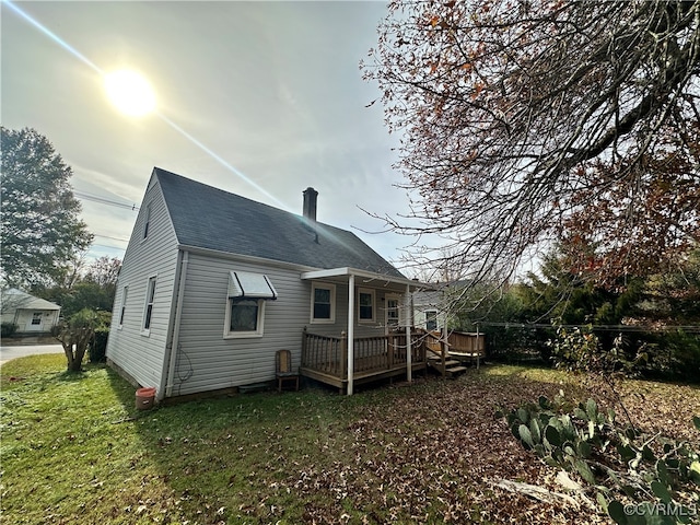 rear view of house with a wooden deck and a yard