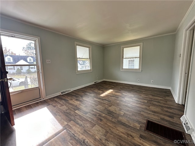 spare room with a wealth of natural light, crown molding, and dark wood-type flooring