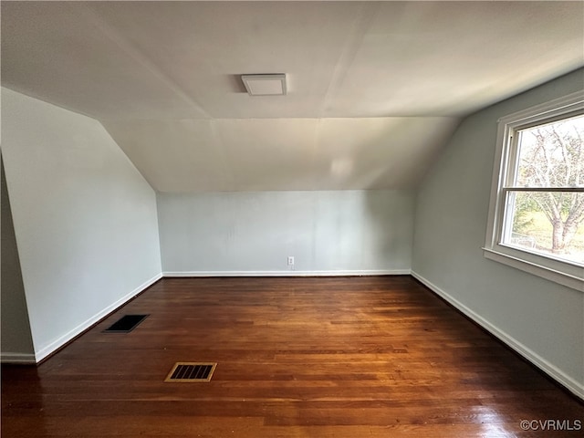 additional living space with vaulted ceiling and dark hardwood / wood-style floors