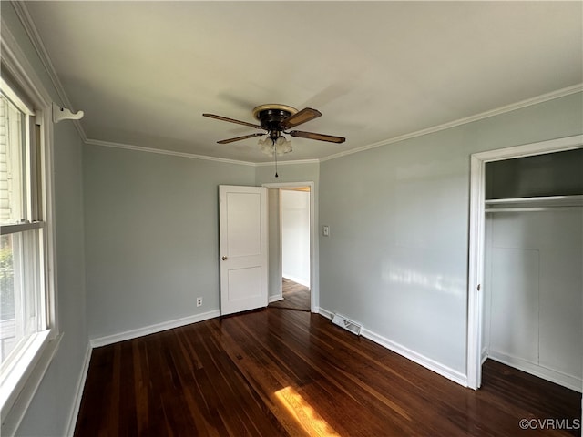 unfurnished bedroom with ceiling fan, dark hardwood / wood-style floors, crown molding, and a closet