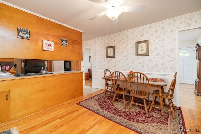 dining space with ceiling fan, ornamental molding, and light hardwood / wood-style flooring