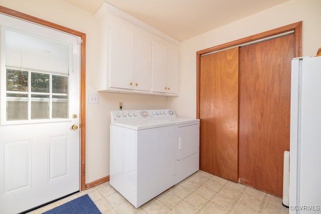 laundry room featuring washer and dryer and cabinets